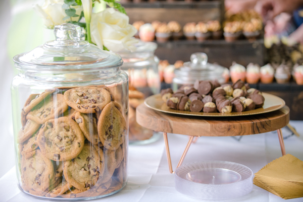 Close up of Chocolate chip cookies in a glass jar with rustic decor in background with desserts on them at fawn hollow acres