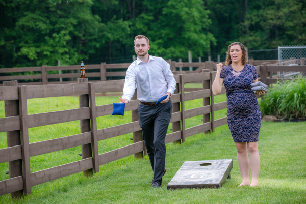 A couple playing corn hole at the reception at Fawn Hollow Acres 