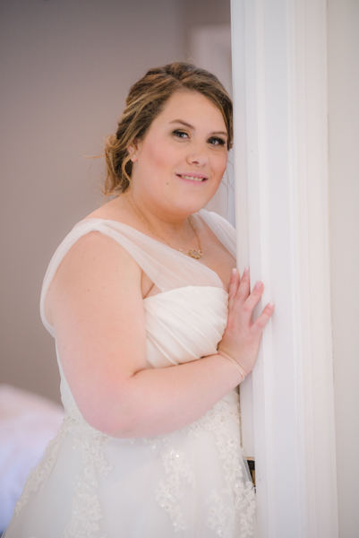 Soft lighting of a bride standing at bedroom door at Fawn Hollow Acres