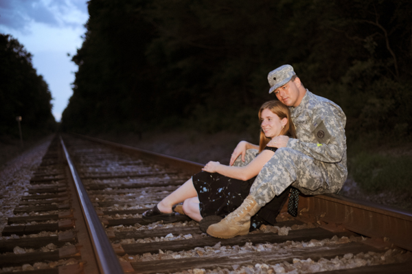 Army photo of couple sitting on train tracks
