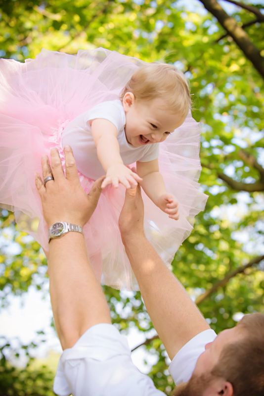 baby girl in tutu being tossed up in air by daddy