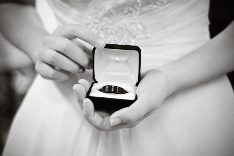 black and white photo of bride holding grooms wedding ring