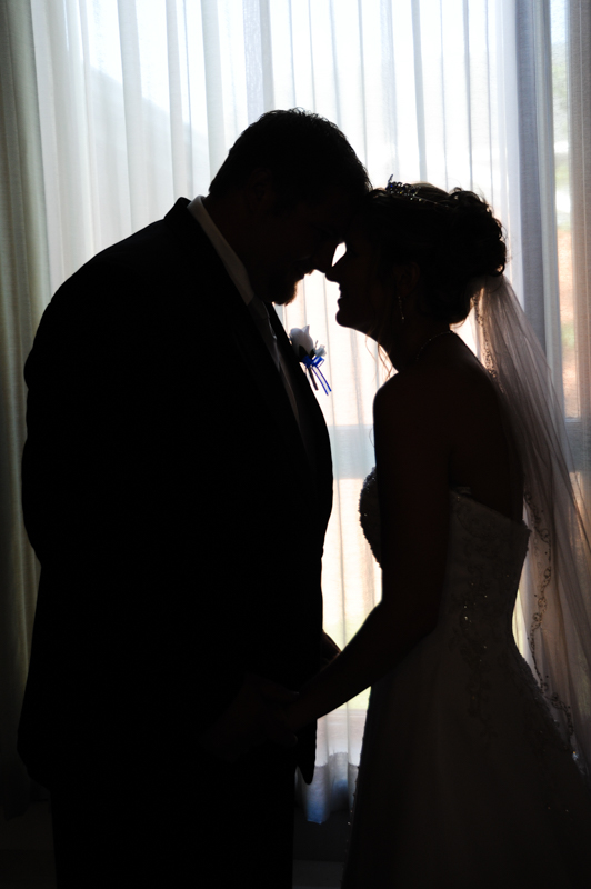 silhouette of bride and groom in front of a window